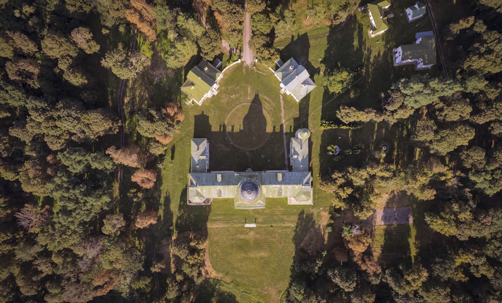 an aerial view of a church surrounded by trees