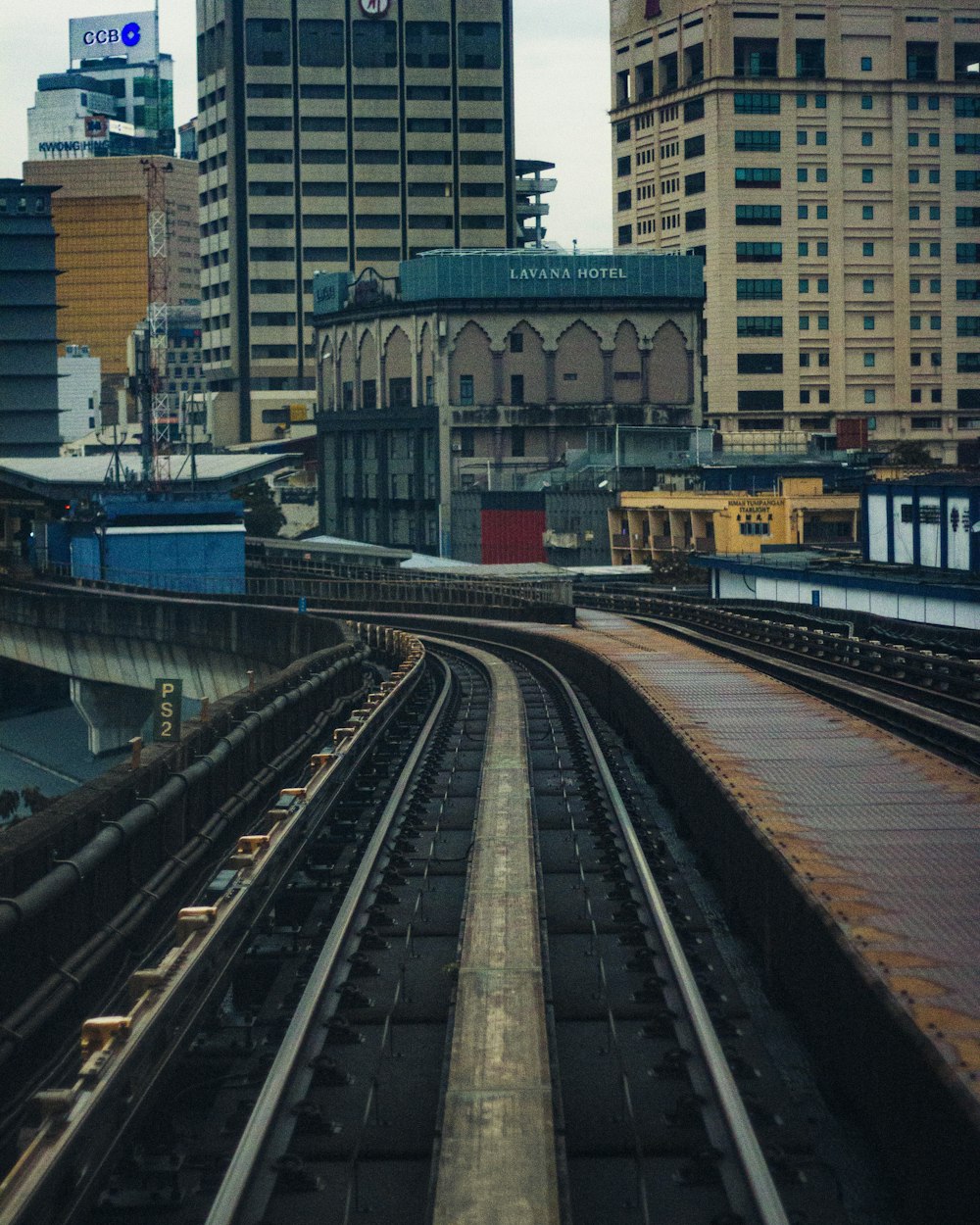 a train traveling down train tracks next to tall buildings