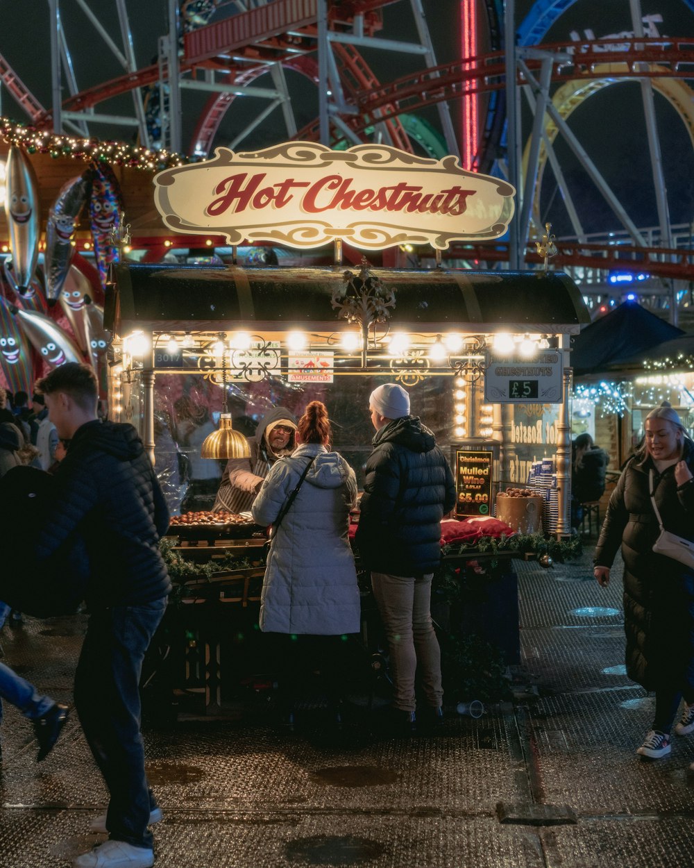 a group of people standing in front of a food stand