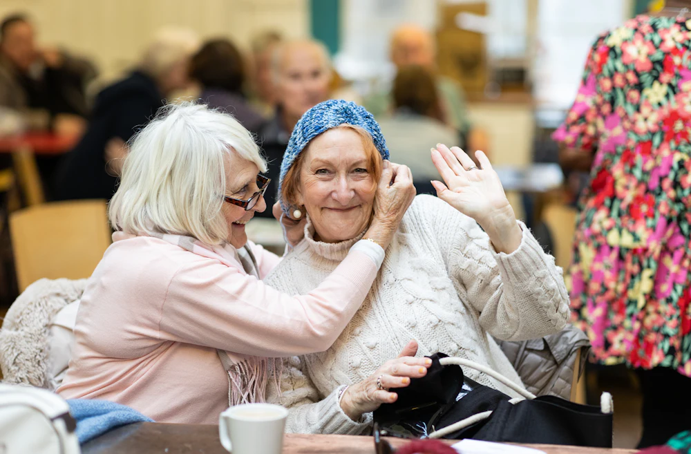 Two community members sharing a warm, joyful moment together