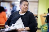 a woman sitting in a chair holding a piece of paper