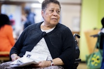 a woman sitting in a chair holding a piece of paper