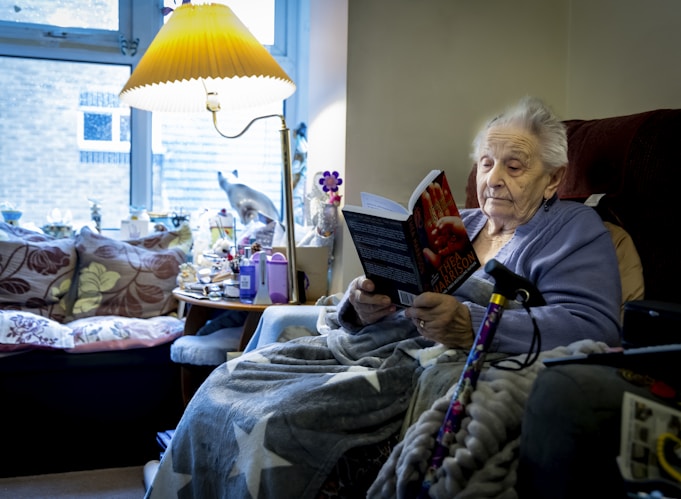 a woman sitting in a chair reading a book