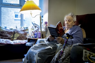 a woman sitting in a chair reading a book