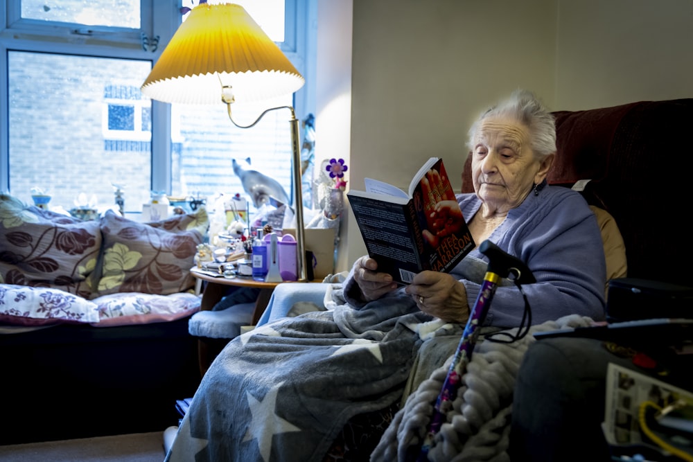 a woman sitting in a chair reading a book