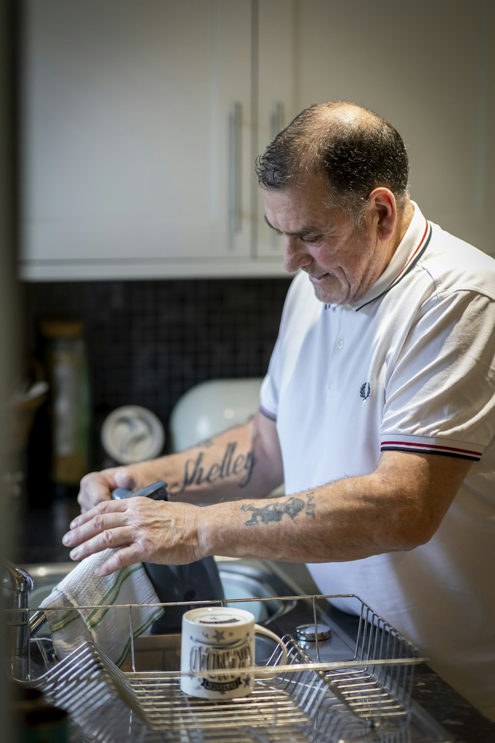 a man in a kitchen washing dishes in a dishwasher