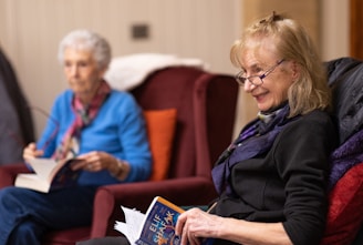 a woman sitting in a chair reading a book