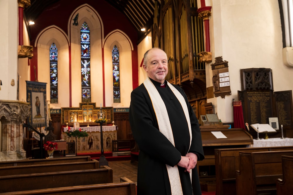 a man in a priest's robes standing in a church