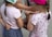 A group of children are standing close together, engaging in an activity. They are wearing colorful clothes and hats, and their arms are intertwined, indicating playfulness or a game.
