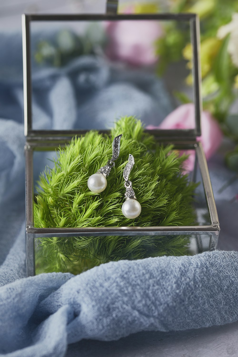 a close up of a pair of earrings in a box