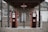 Two vintage Phillips 66 gas pumps stand under a wooden canopy in front of a rustic stone building. One pump is labeled Ethyl and the other Regular. The building features a sign for a cafe and another for Spencer Garage, with a gravel pathway leading up to it.