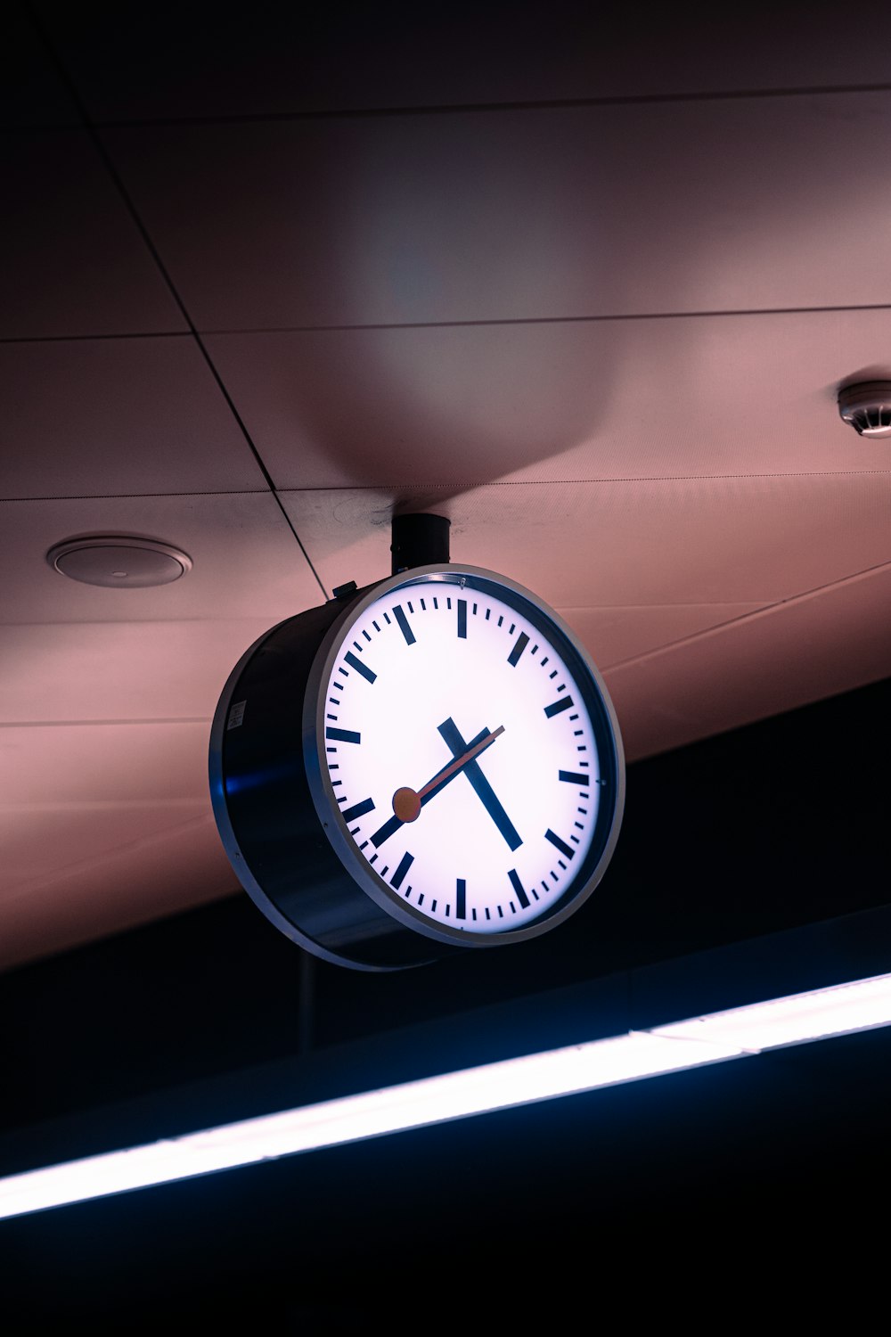 a clock hanging from the ceiling of a building