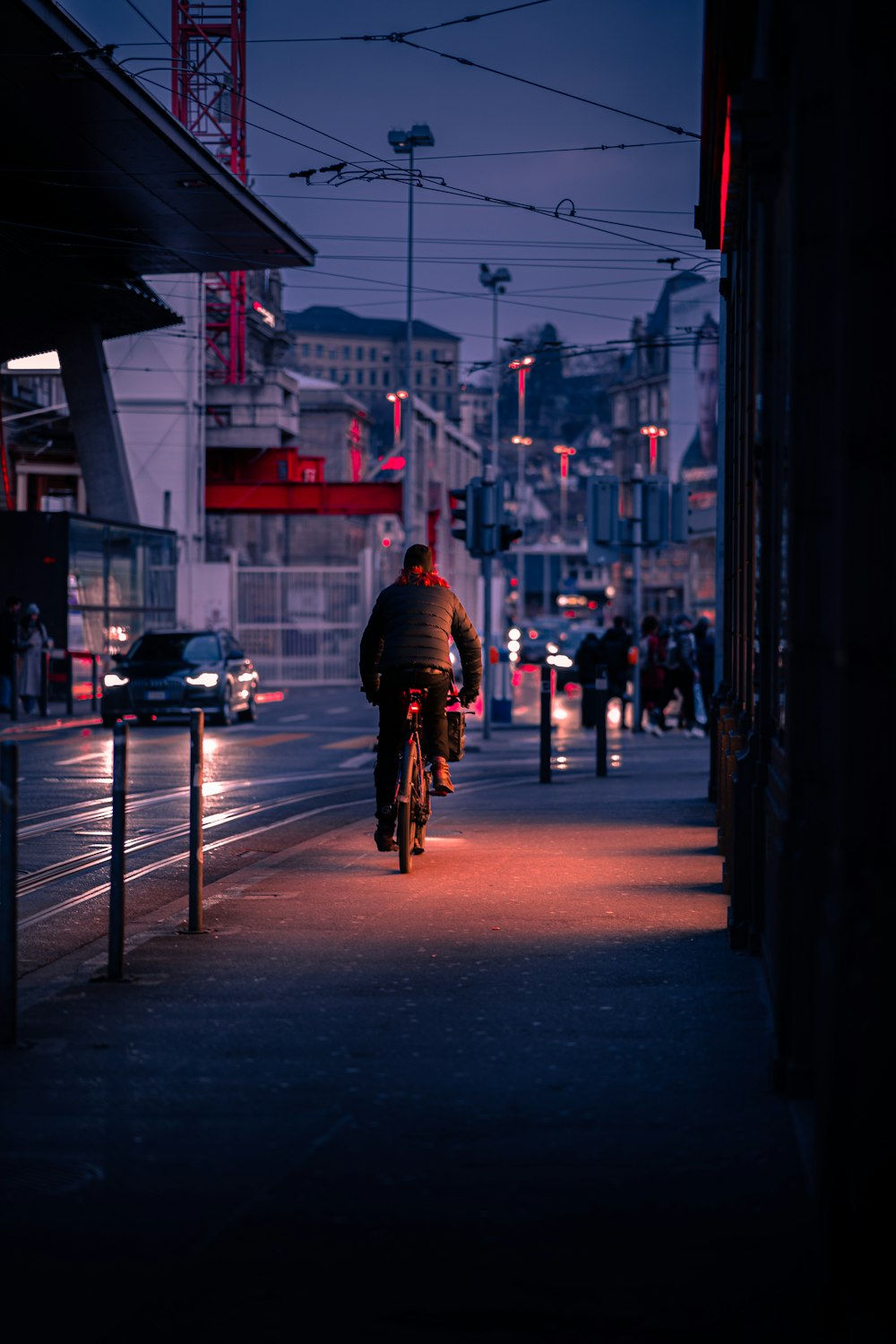Un hombre montando en bicicleta por una calle por la noche