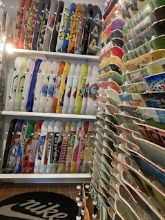 Shelves filled with skate accessories like helmets, pads, and stickers.