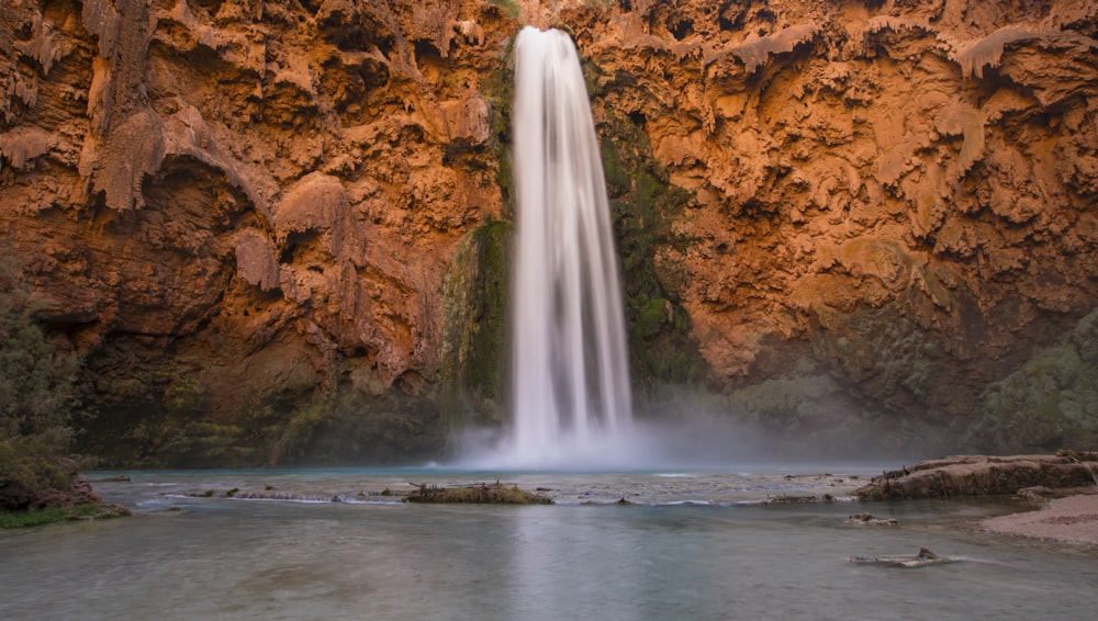 a large waterfall with a long waterfall cascading down it's side