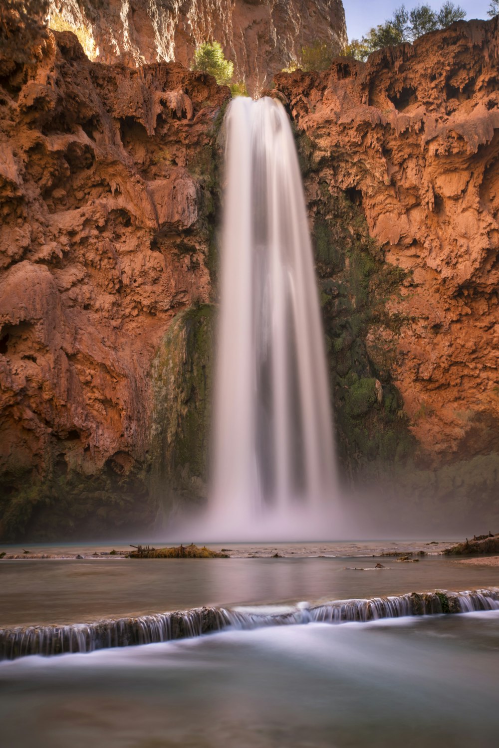 a long exposure of a waterfall in the middle of a body of water