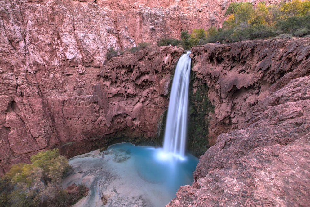 a waterfall with a blue pool in the middle of it