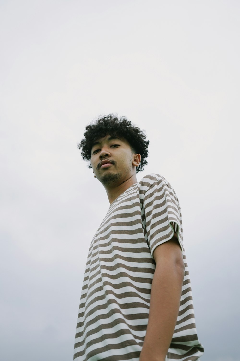 a man standing in front of a cloudy sky