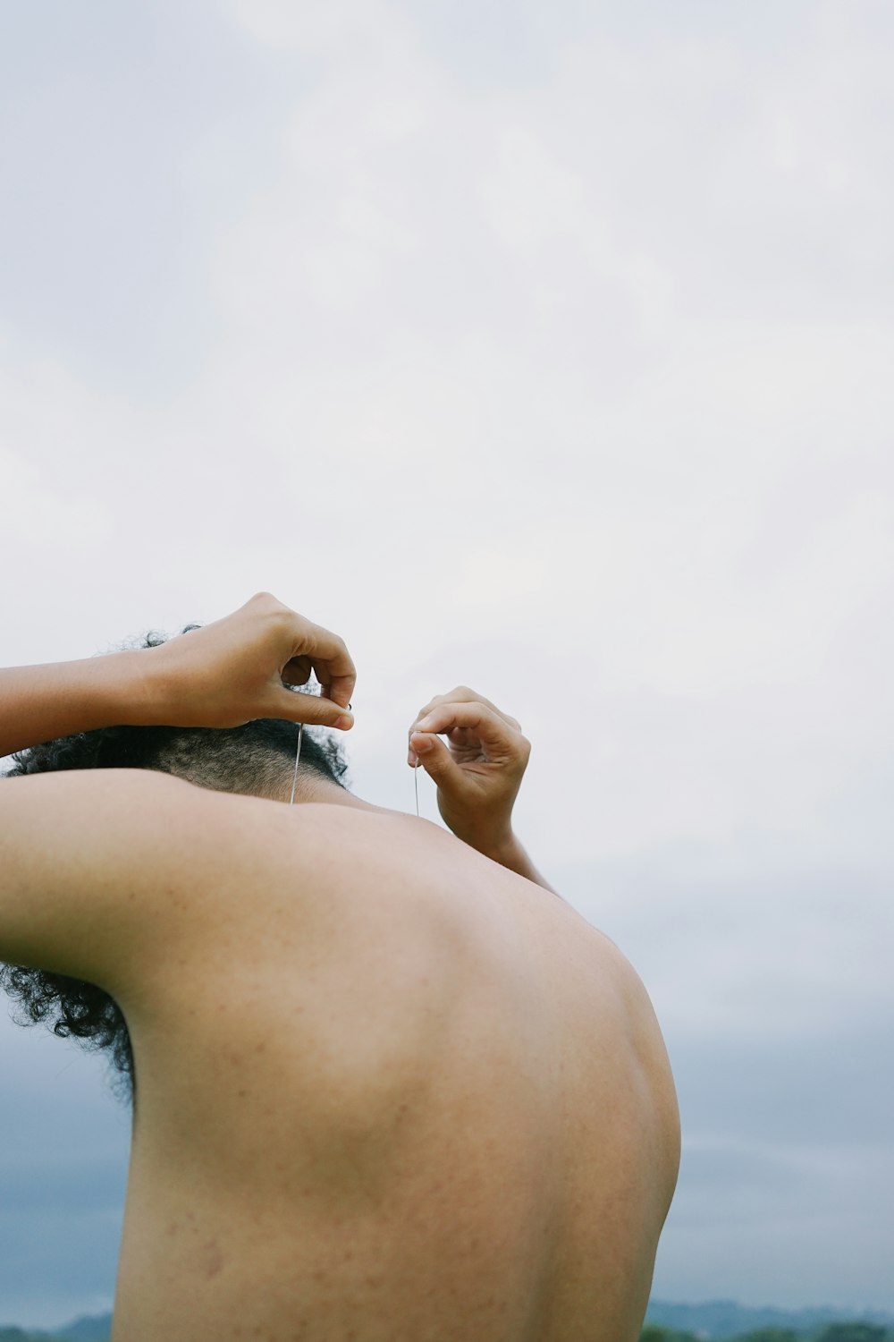 a man with no shirt on standing in a field