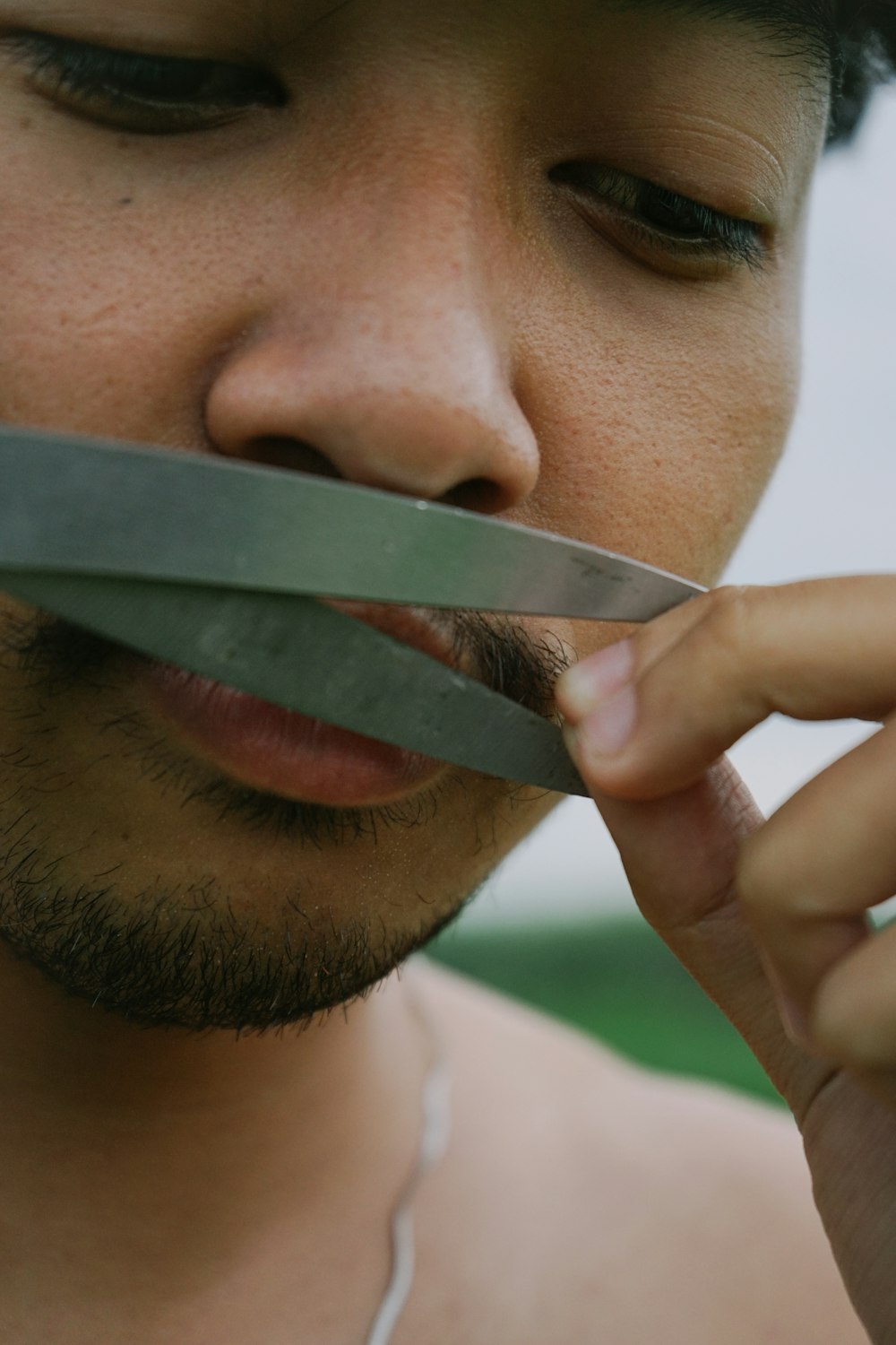 a man holding a pair of scissors in his mouth