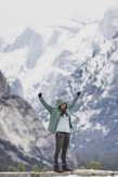 a woman standing on top of a snow covered mountain