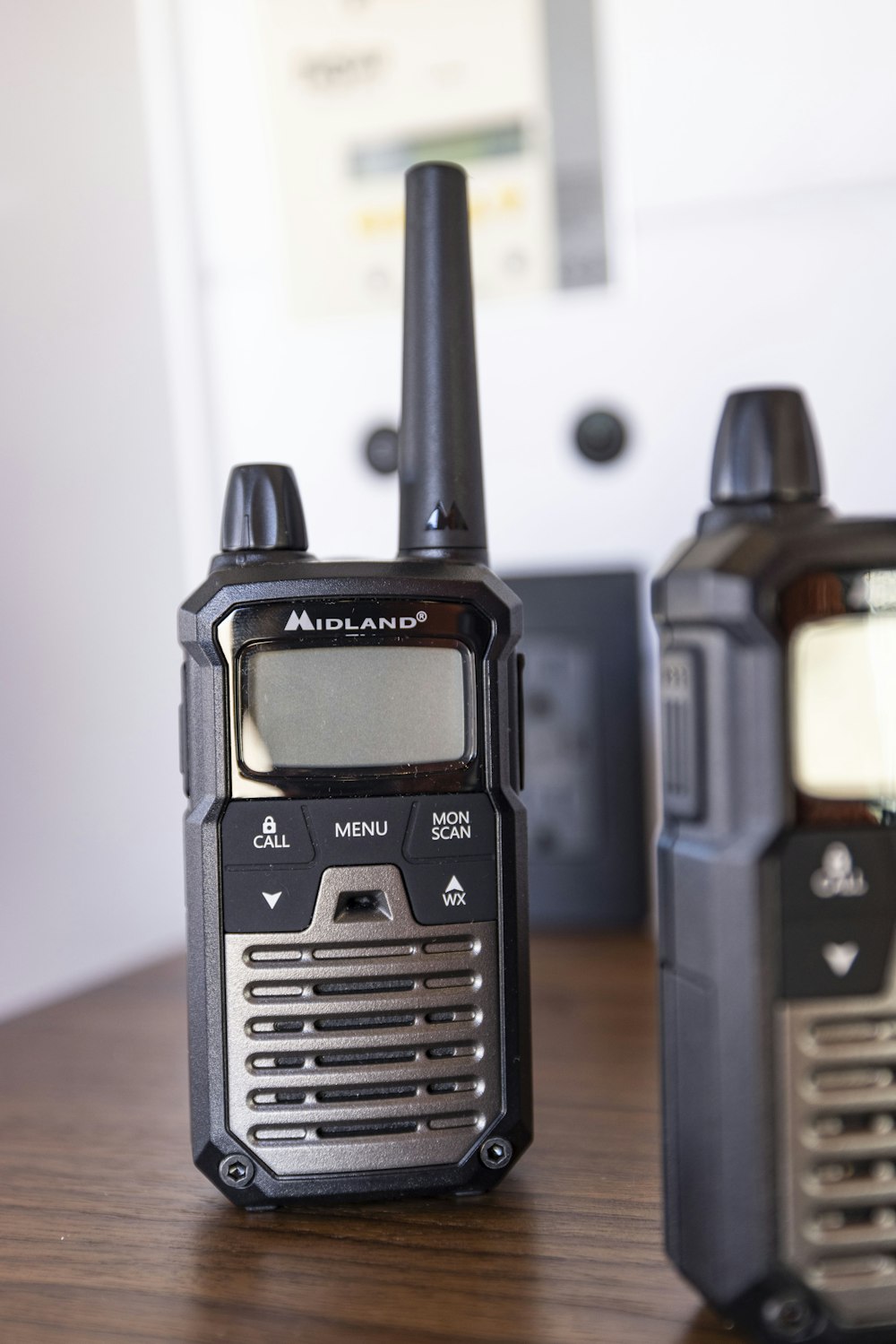 two walkie talkies sitting on top of a wooden table