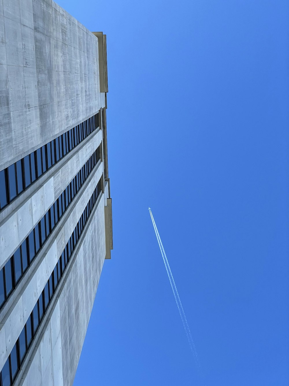 an airplane flying in the sky over a building