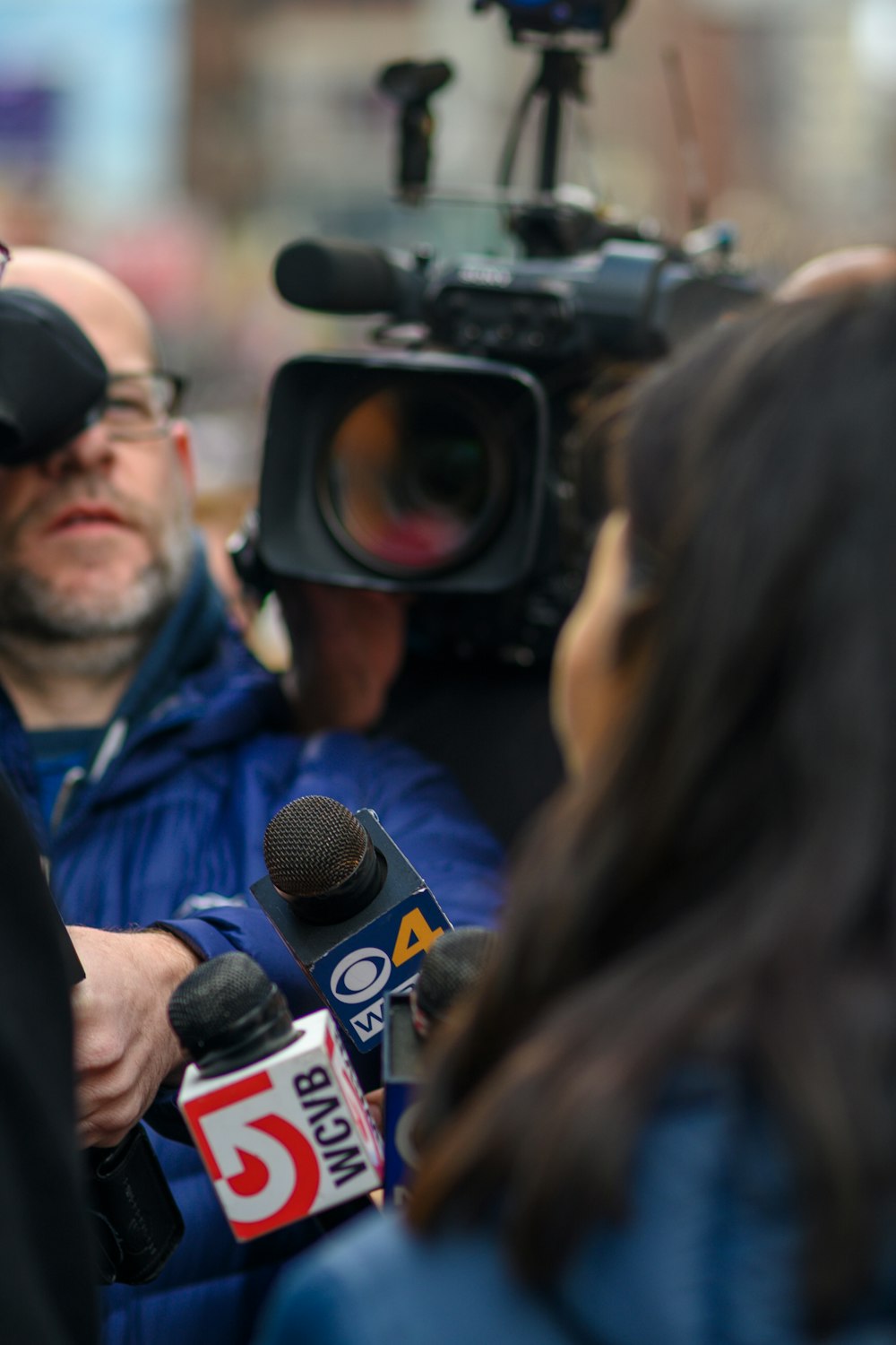 a man is surrounded by reporters and microphones