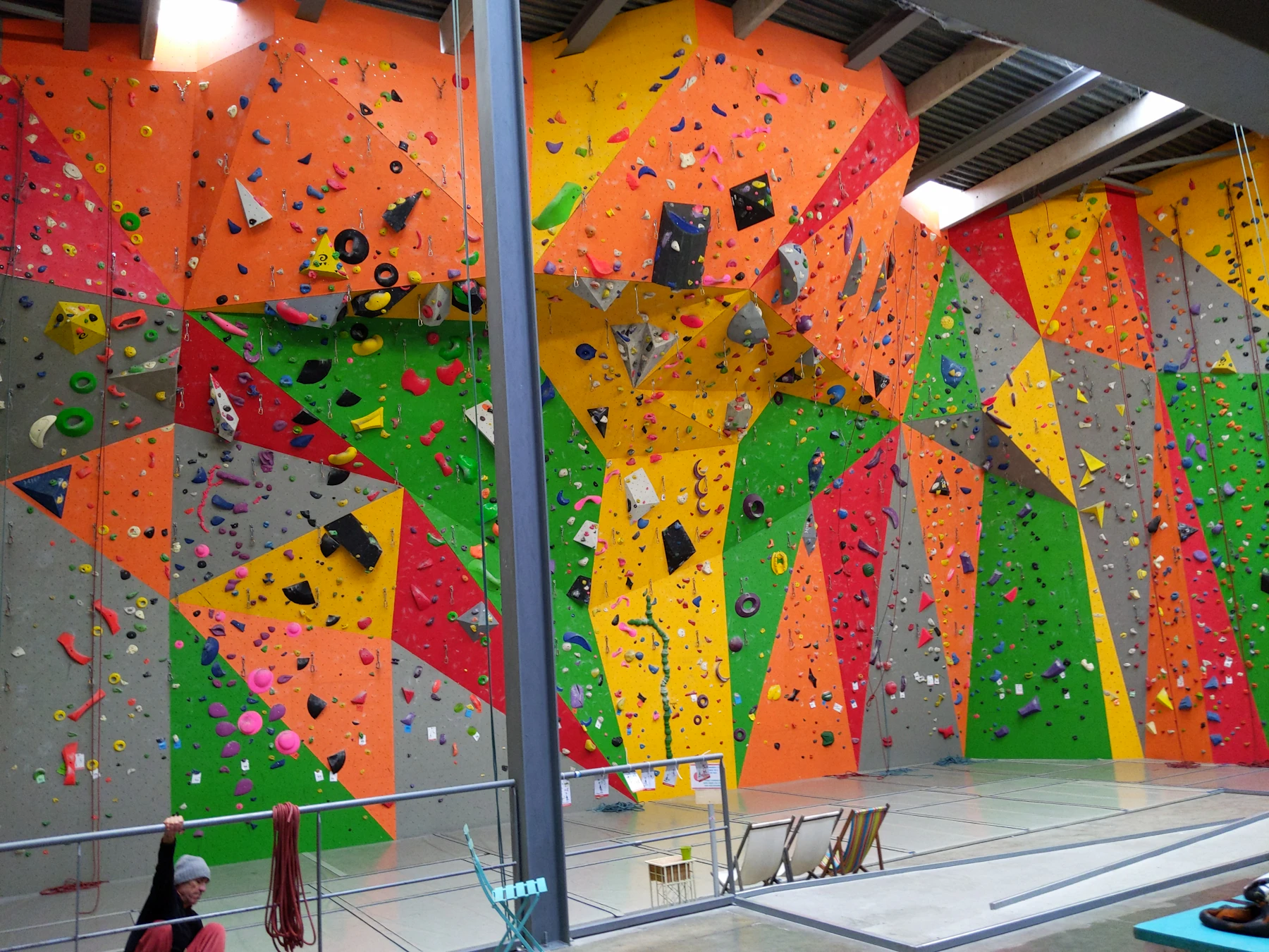 An indoor bouldering gym with bright angled walls studded with holds