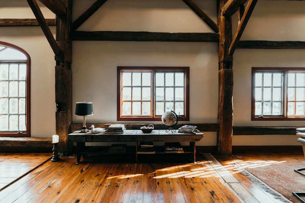 una sala de estar con suelos de madera y ventanas