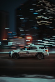 a police car driving down a city street at night