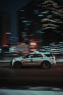 a police car driving down a city street at night