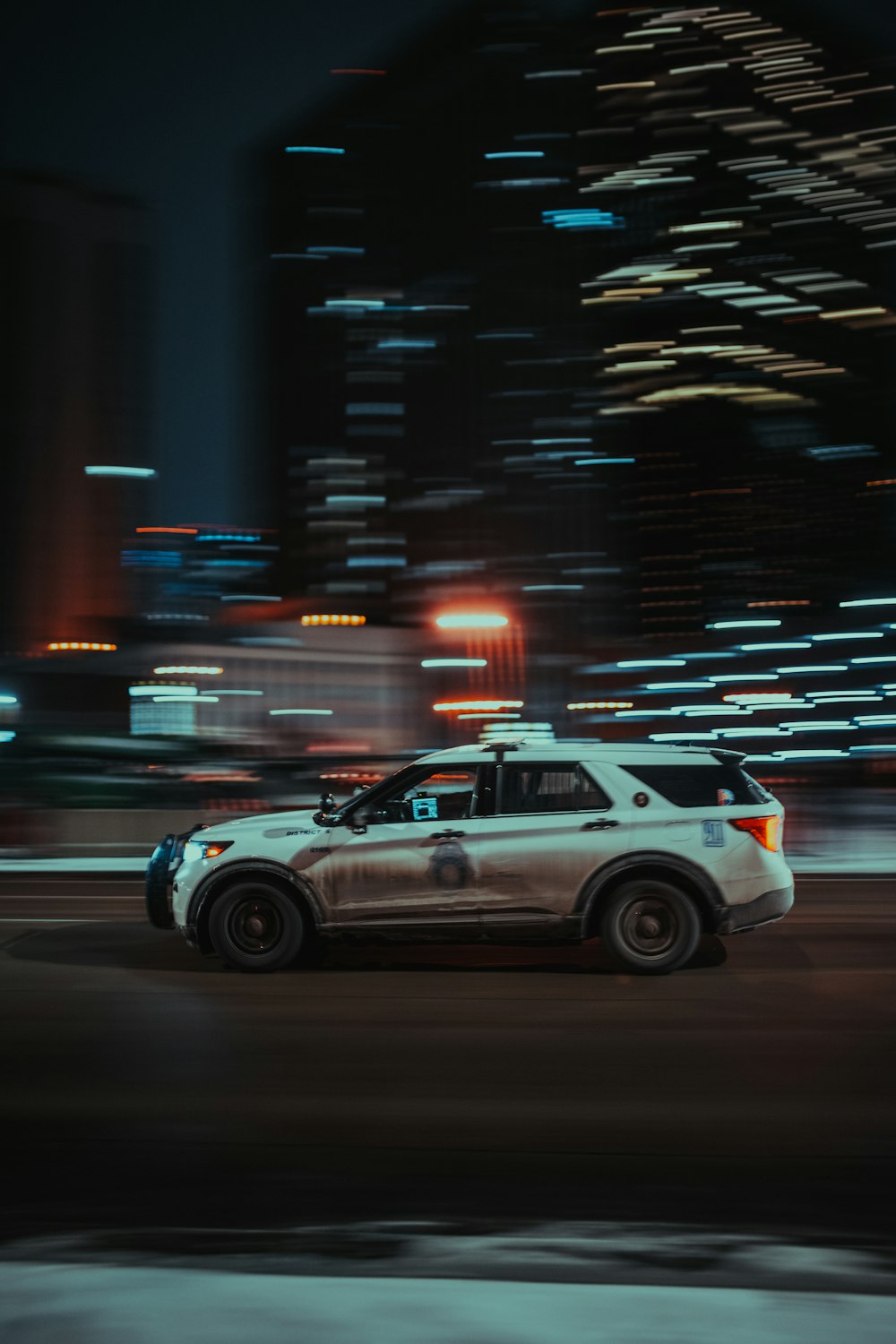 Un coche de policía conduciendo por una calle de la ciudad por la noche