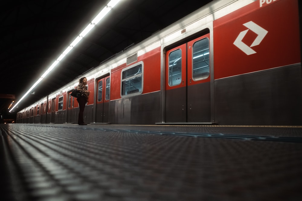 a red and grey train at a train station