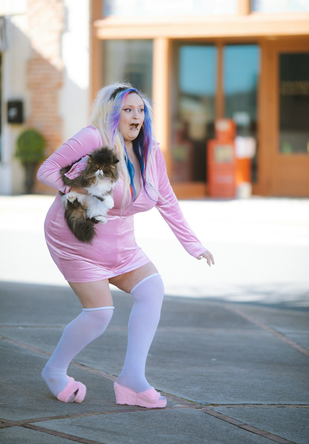 a woman in a pink dress holding a dog