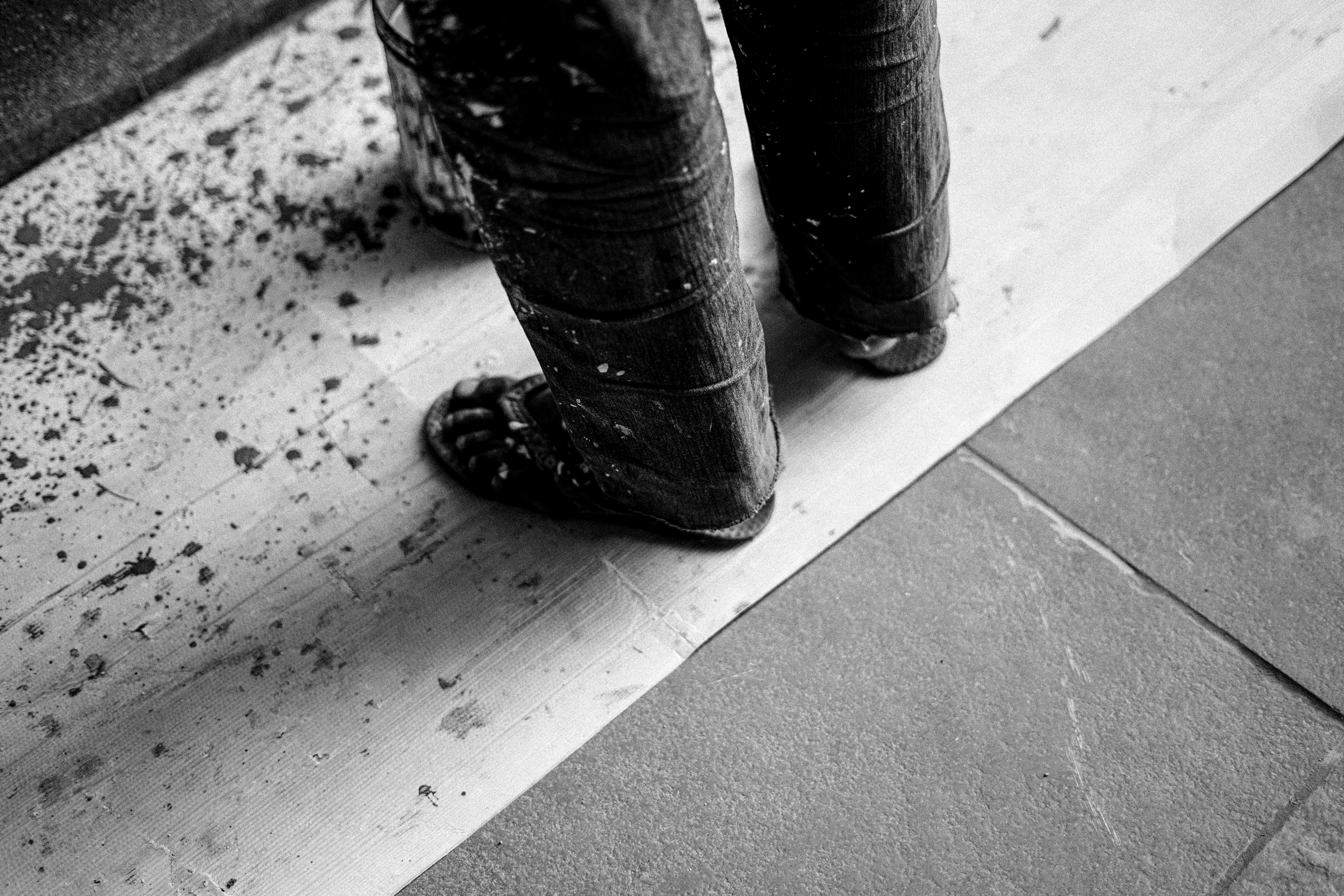 ein Schwarz-Weiß-Foto der Füße und Stiefel einer Person
