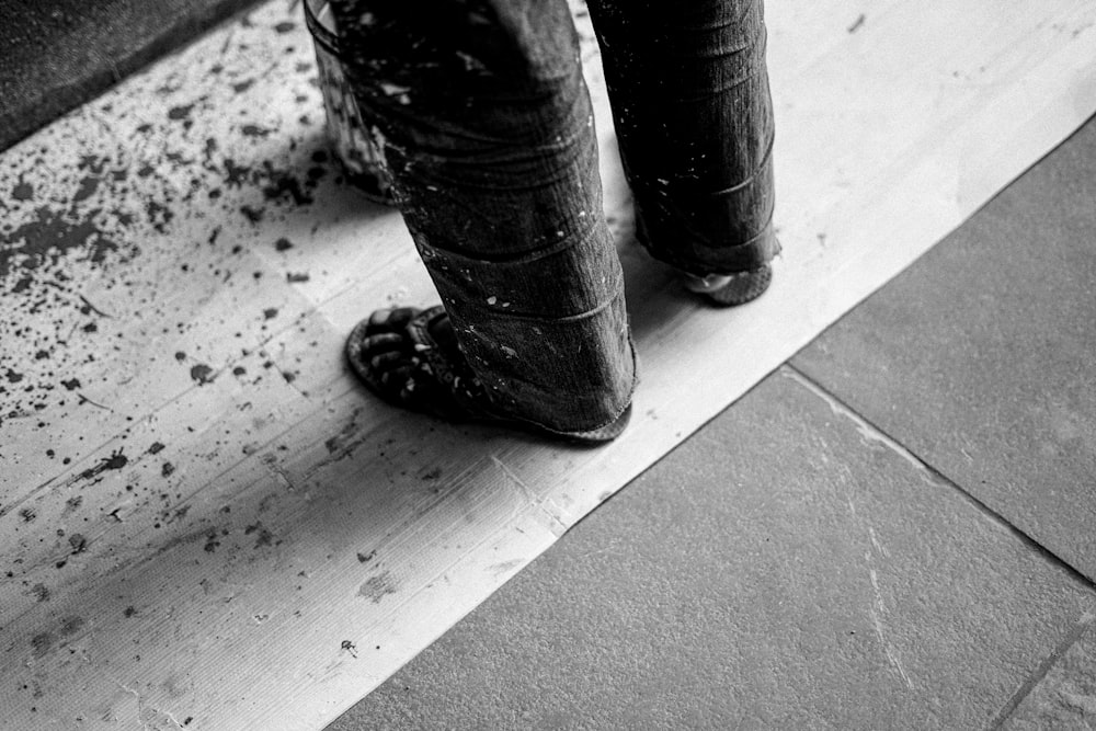 a black and white photo of a person's feet and boots