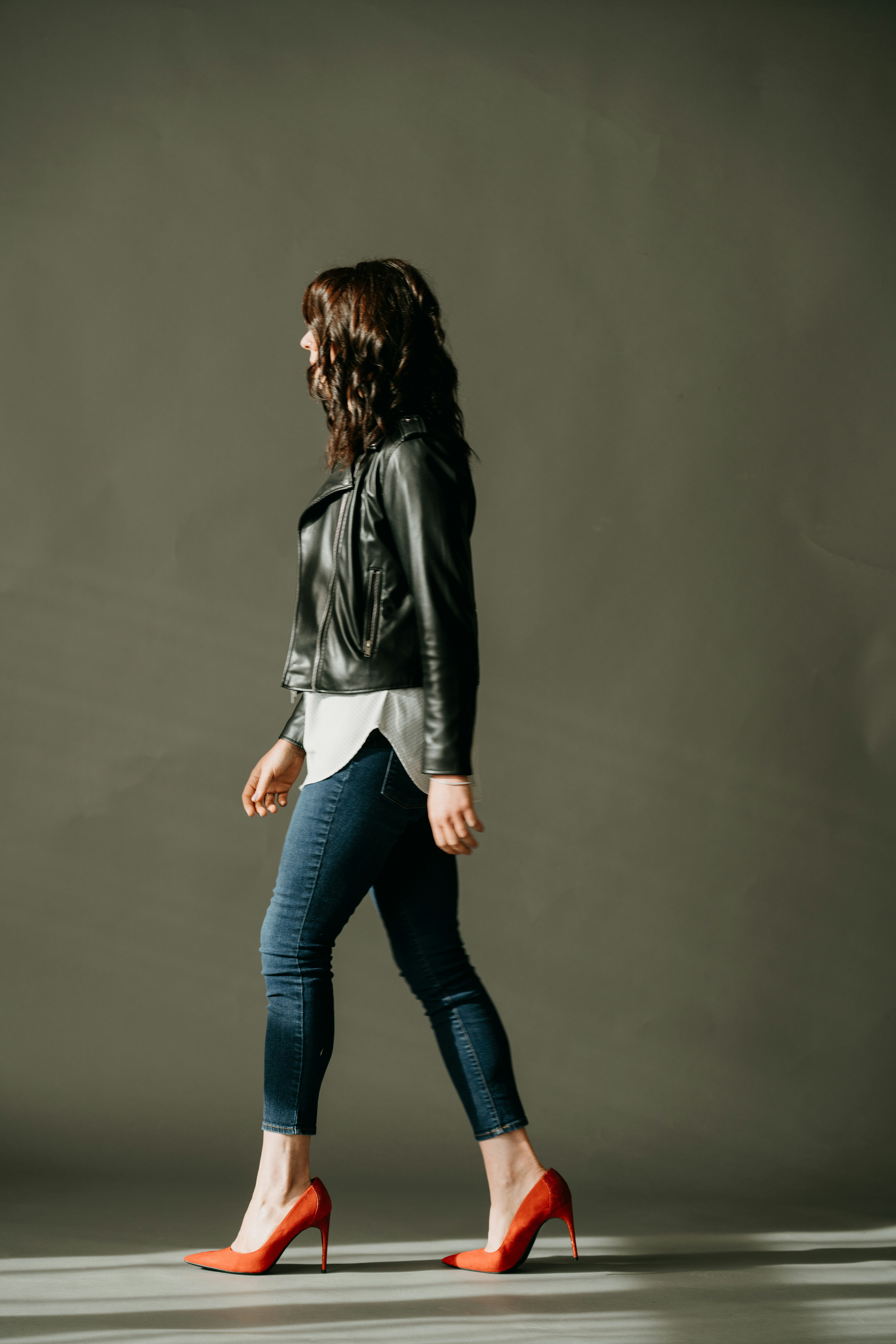 a woman in a black leather jacket is walking