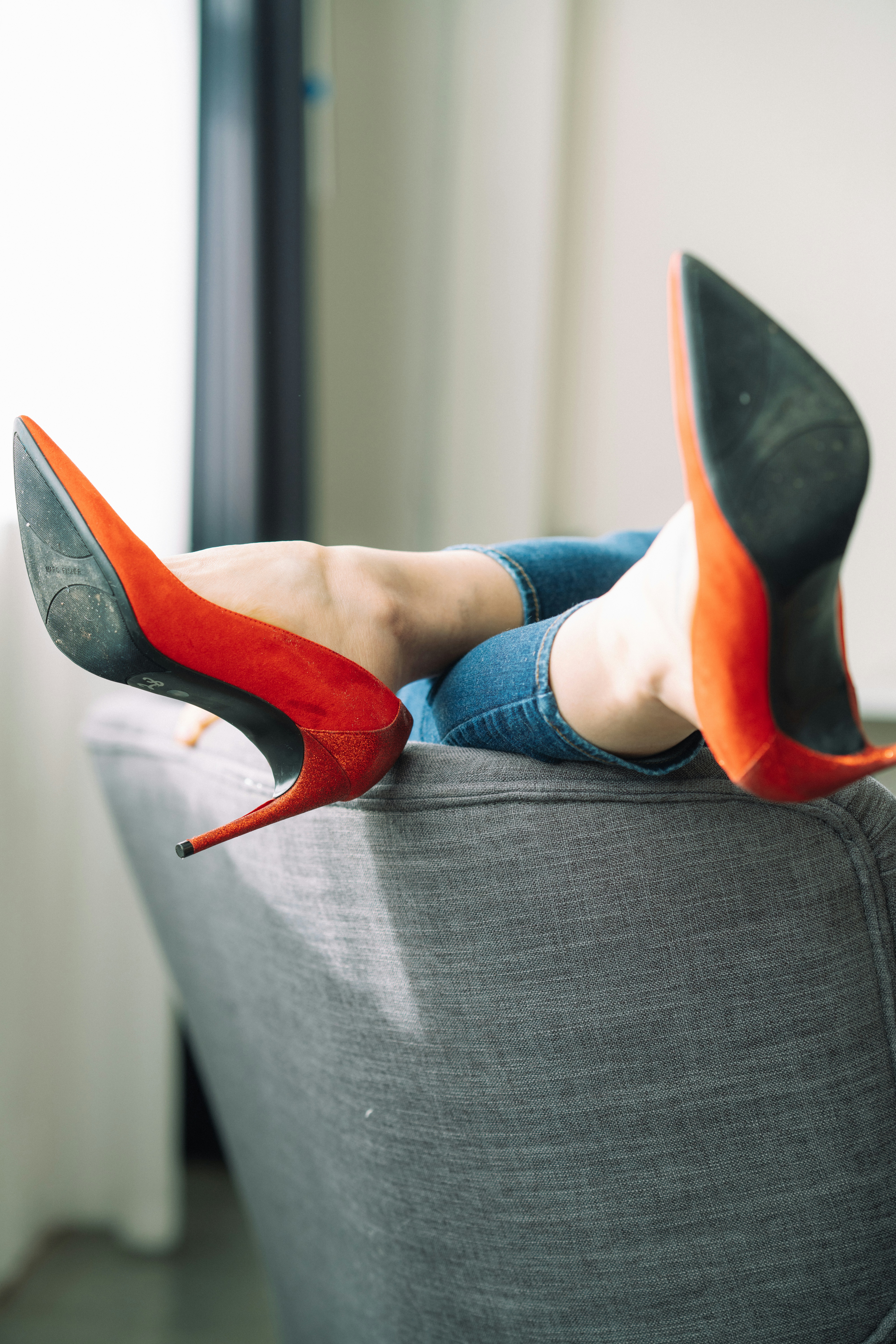 a woman laying on top of a gray couch
