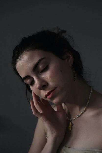 Portrait of Simonne Oliveira in a serene, softly lit space surrounded by crystals and spiritual symbols.