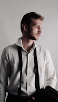 a man in a white shirt and black suspenders