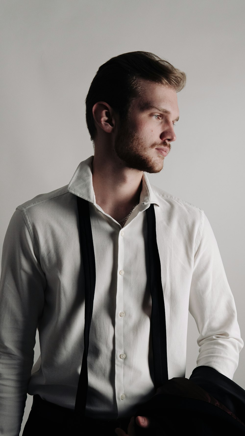 a man in a white shirt and black suspenders
