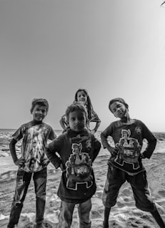 The four kids standing proudly in a freshly cleaned yard, smiling at the camera.