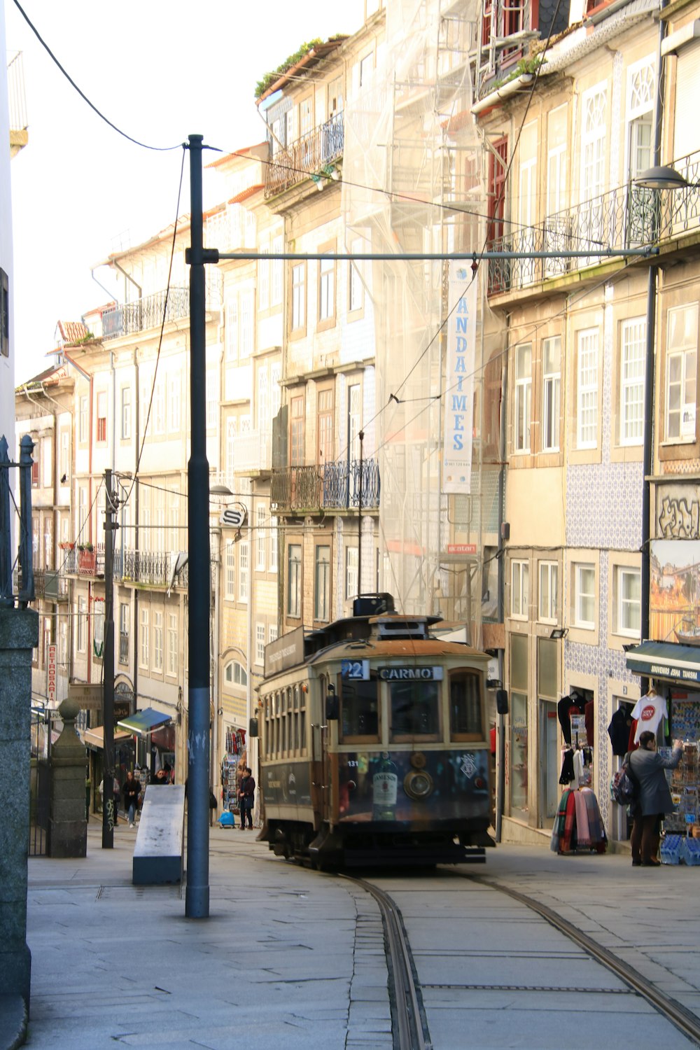 a trolley car traveling down a street next to tall buildings