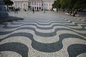 a cobblestone street with a large building in the background