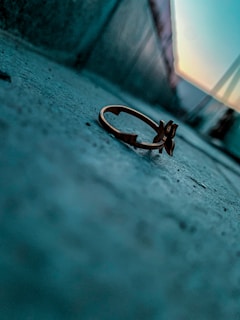 Artistic shot of moon-inspired rings stacked on a textured stone, catching the light in a warm, celestial glow