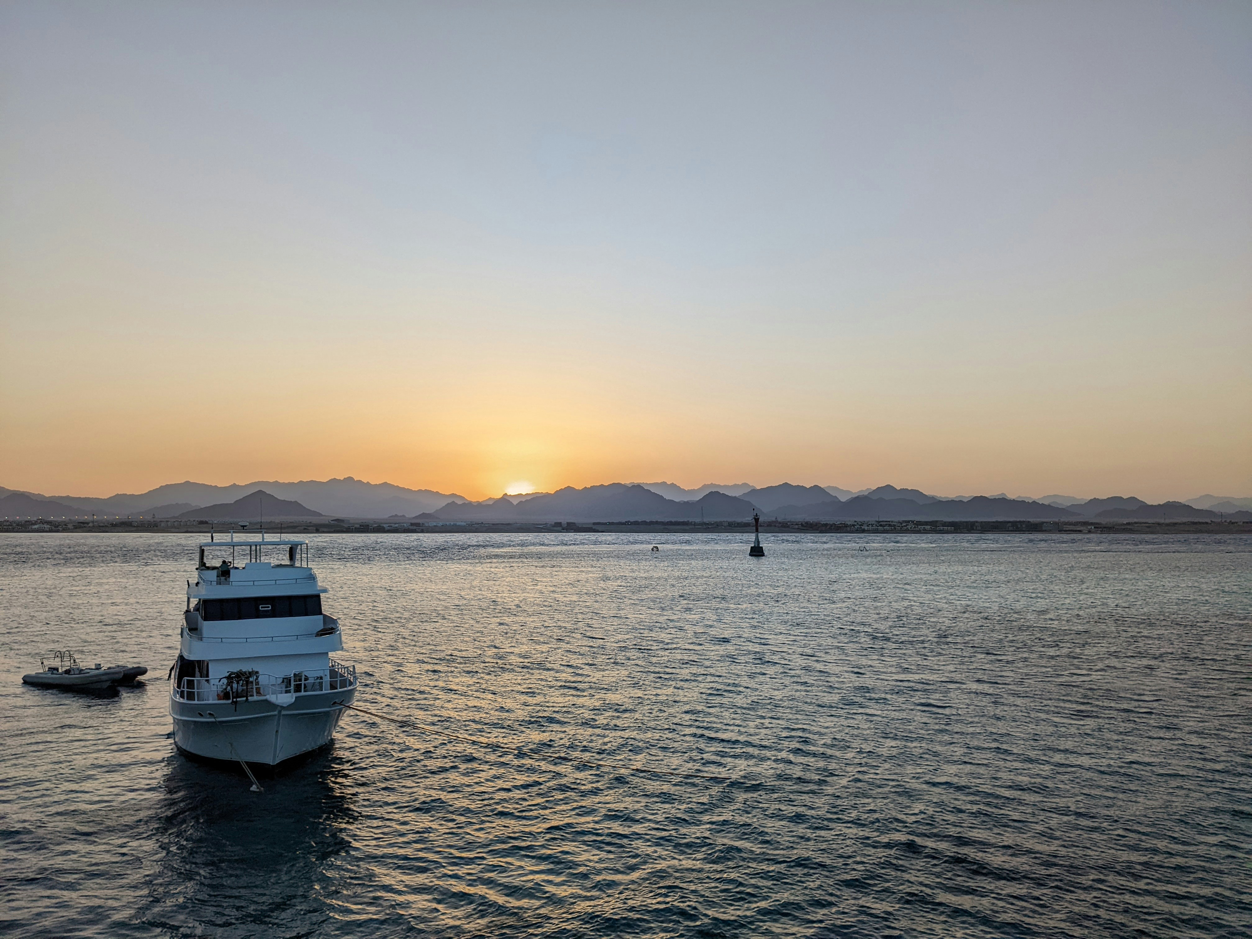 Ein weißes Boot, das auf einem großen Gewässer schwimmt