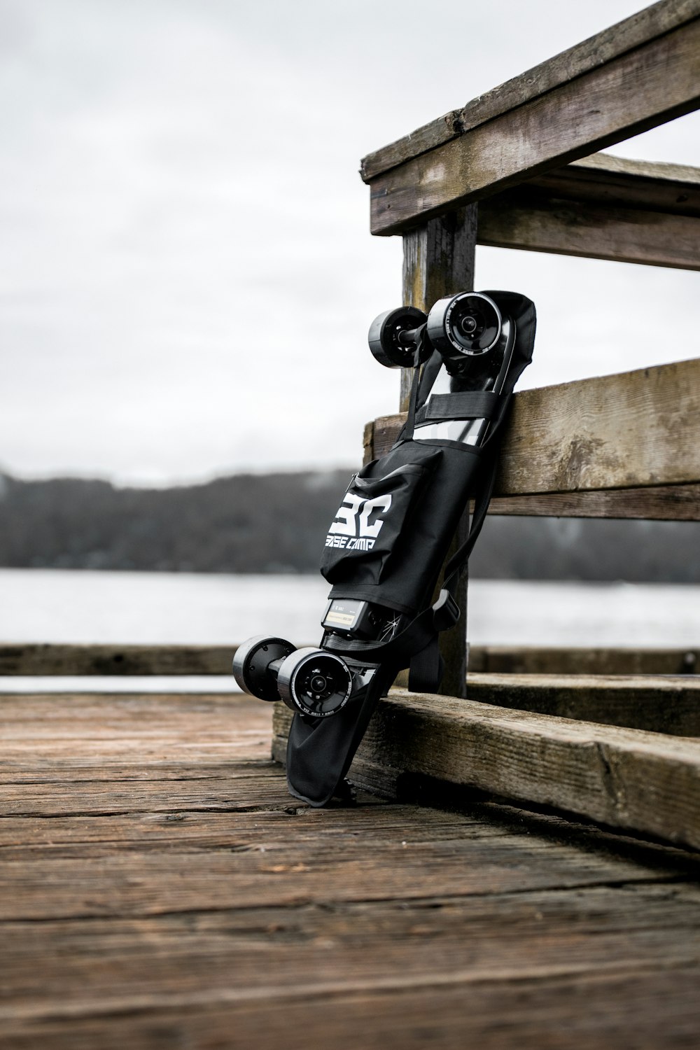 a black skateboard leaning against a wooden bench