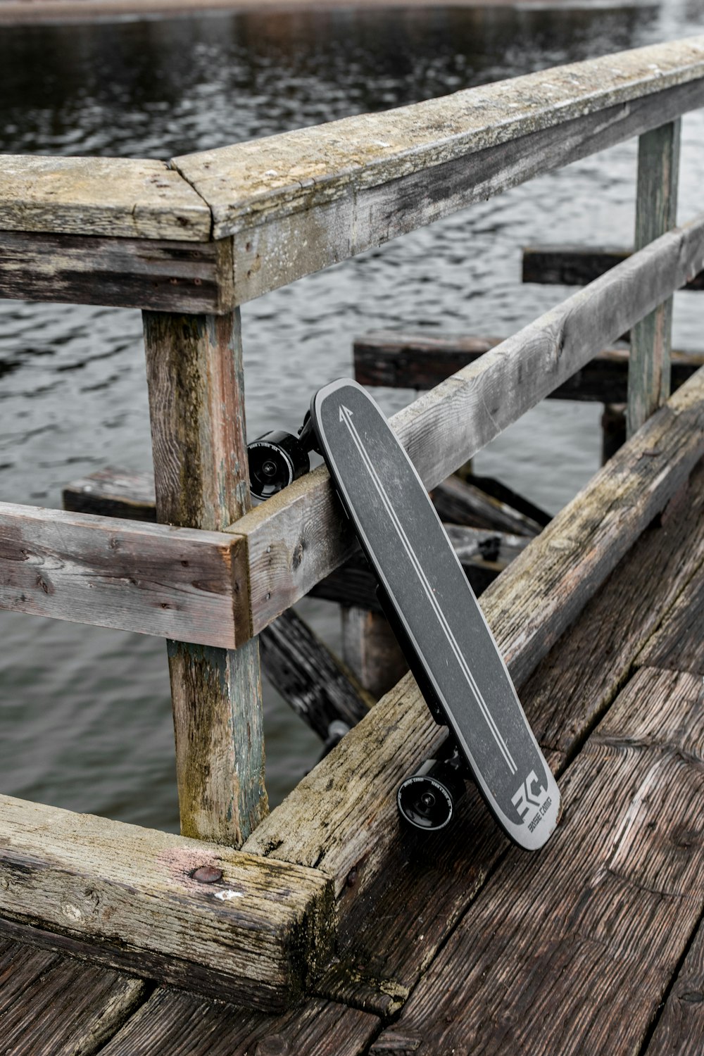 a skateboard leaning against a rail on a pier