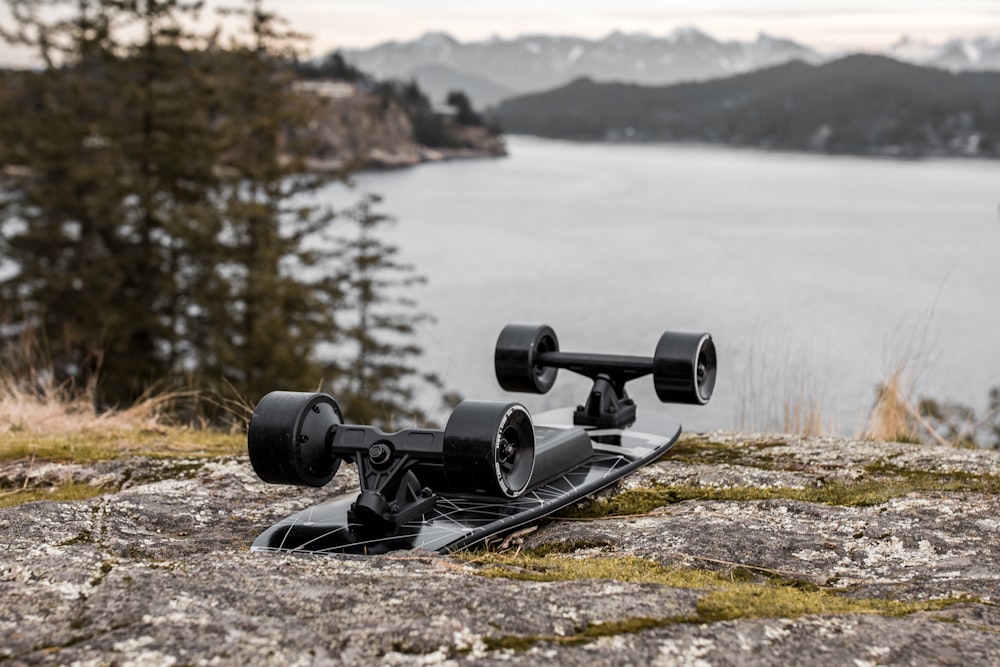 a skateboard sitting on top of a rock next to a body of water
